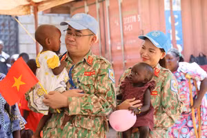 Miembros del Hospital de Campaña de Nivel 2 número 7 de Vietnam sostienen en brazos a niños del hogar St. Clare, en Juba, capital de Sudán del Sur. (Foto: Tien Phuc)