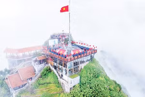 Los jóvenes realizan el saludo a la bandera y entonan el himno nacional en la cima del Fansipan.