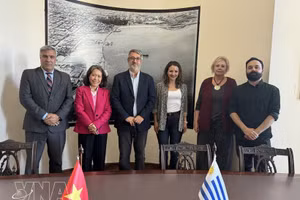 La embajadora Ngo Minh Nguyet (de traje magenta) y el alcalde interino de Montevideo, Justo Onandi (tercero desde la izquierda), junto con representantes de las autoridades locales, posan para una foto tras una sesión de trabajo. (Foto: VNA)