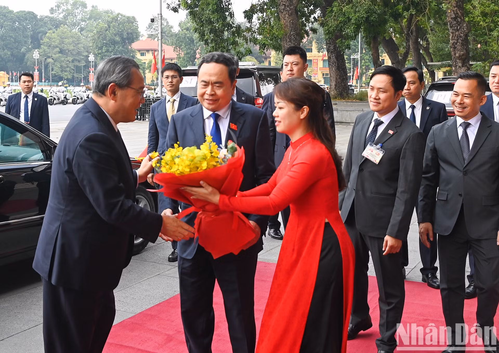 El personal de la Oficina de la Asamblea Nacional entrega flores para dar la bienvenida al primer ministro chino, Li Qiang.