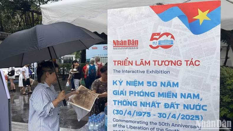 Un lector extranjero muestra interés por la publicación informativa especial de Nhan Dan.