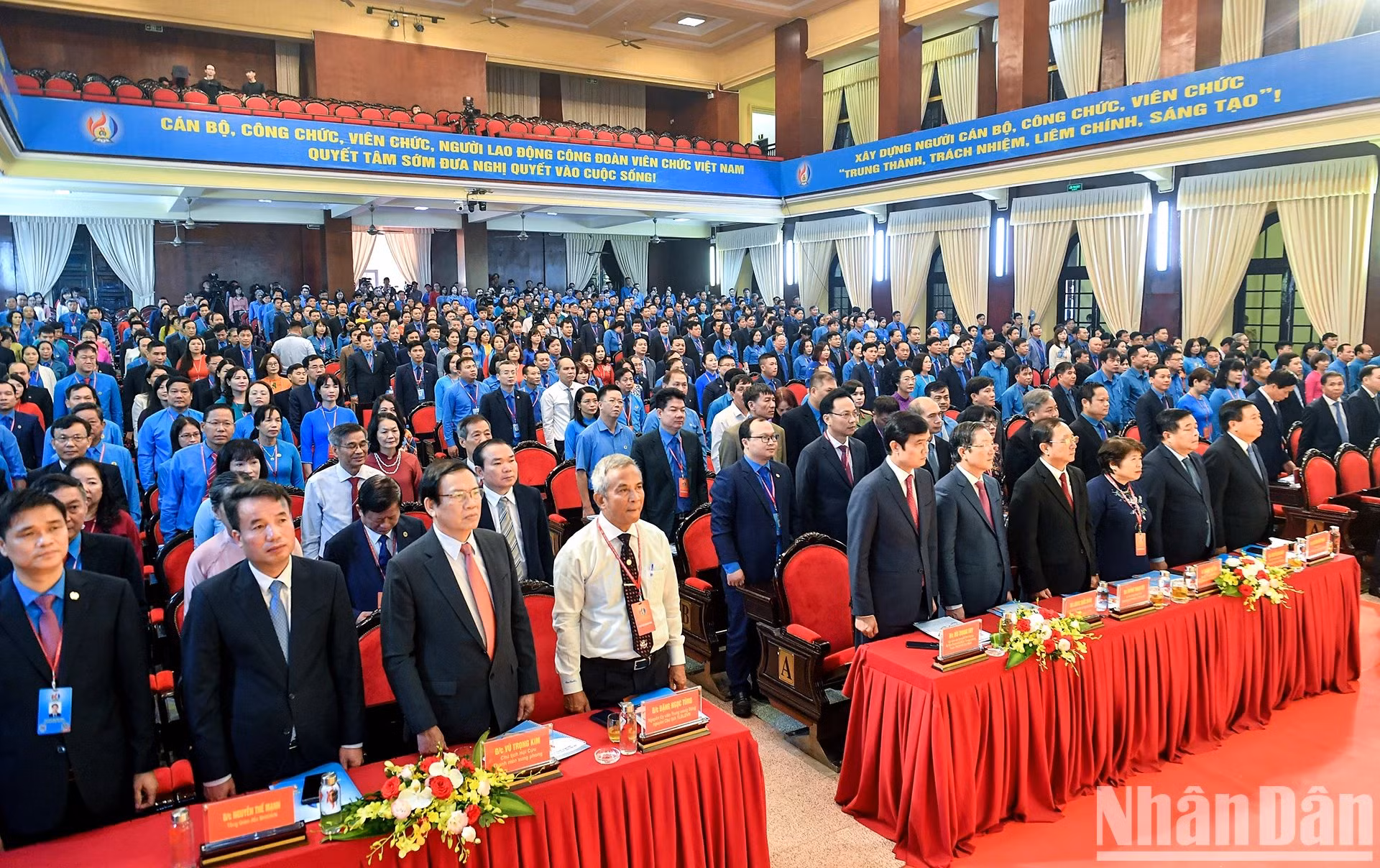 Los delegados realizan la ceremonia de izamiento de la bandera nacional.