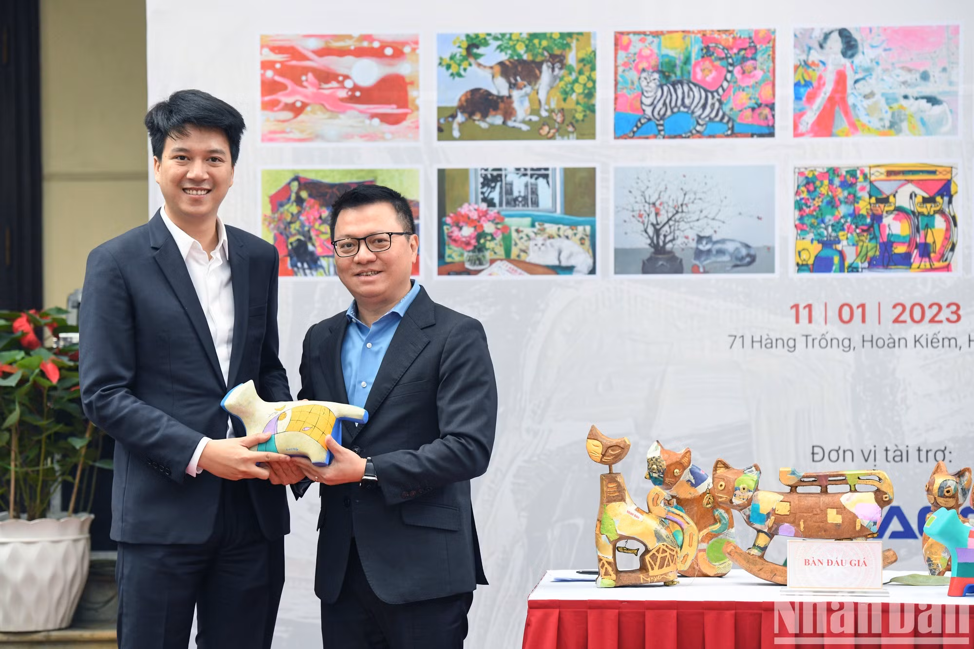 El presidente-editor de Nhan Dan, Le Quoc Minh, se toma una foto con un invitado que ganó la subasta de una escultura original. (Foto: Thanh Dat)