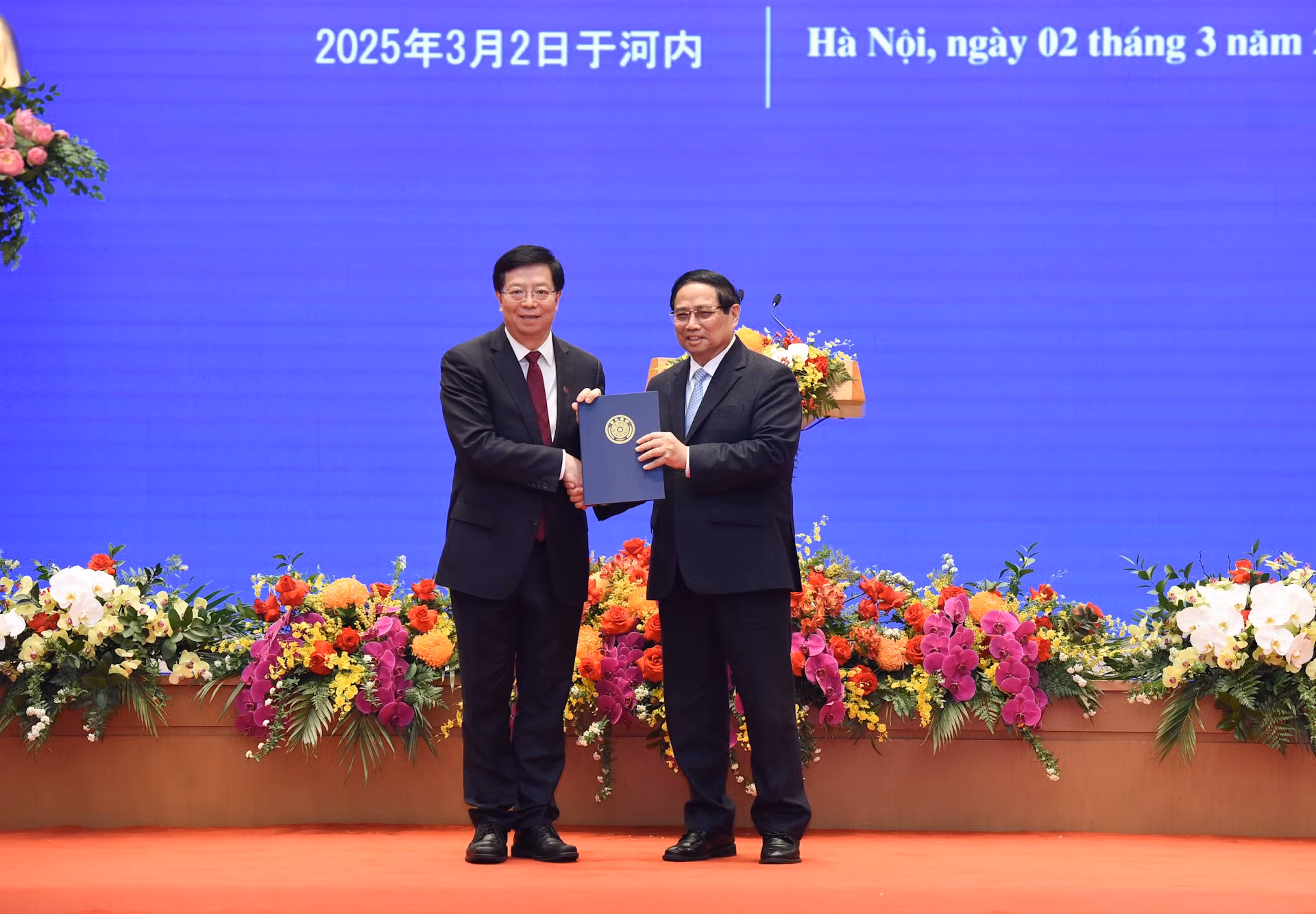 Qiu Yong (izquierda), secretario del Comité del Partido Comunista de China en la Universidad de Tsinghua, entrega el título de "Profesor Honorario" al primer ministro Pham Minh Chinh. (Foto: VNA)