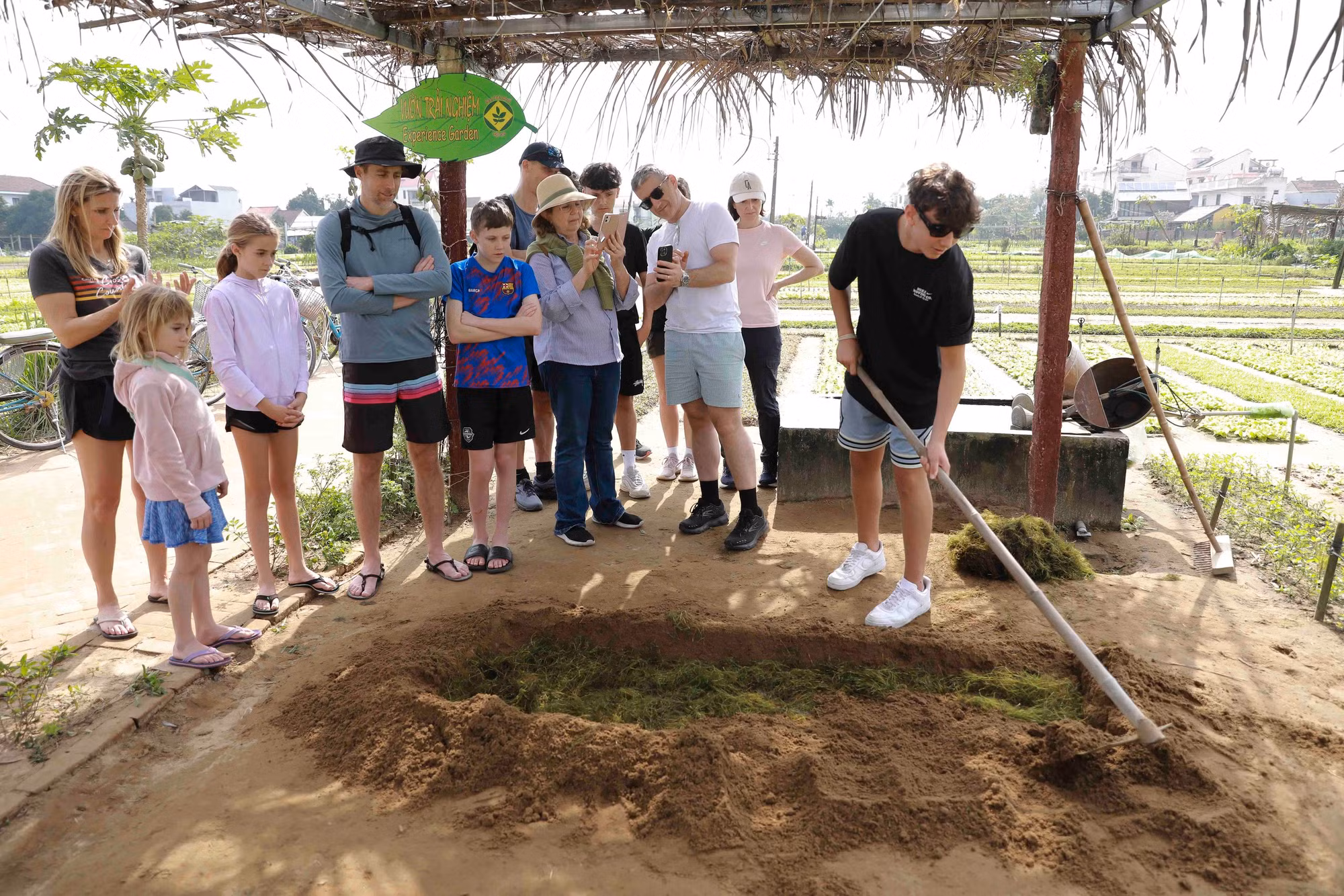 Turistas extranjeros aprenden las prácticas locales de cultivo.