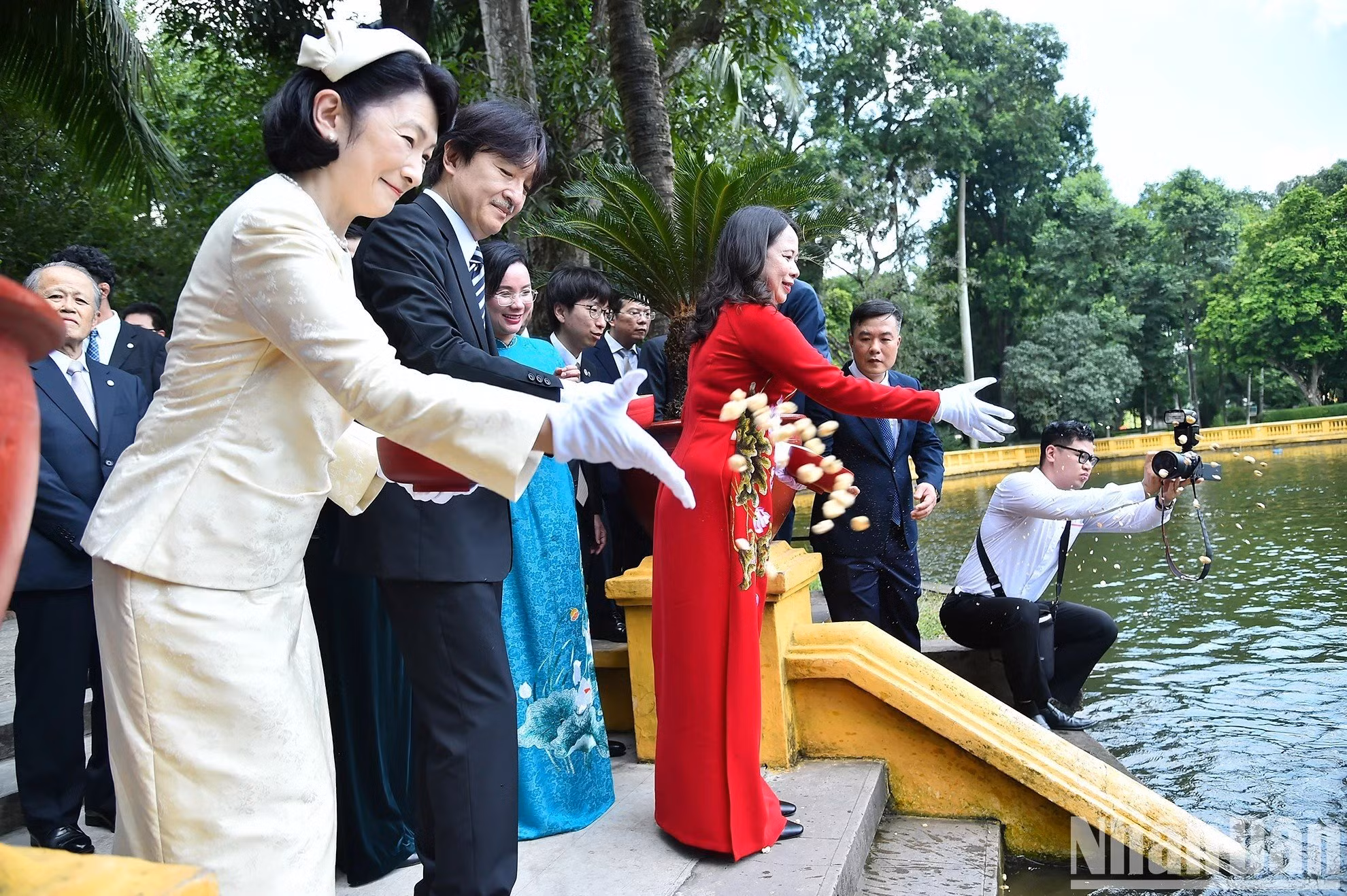 La vicemandataria vietnamita y los invitados japoneses alimentan a los peces en el estanque de peces del tío Ho.