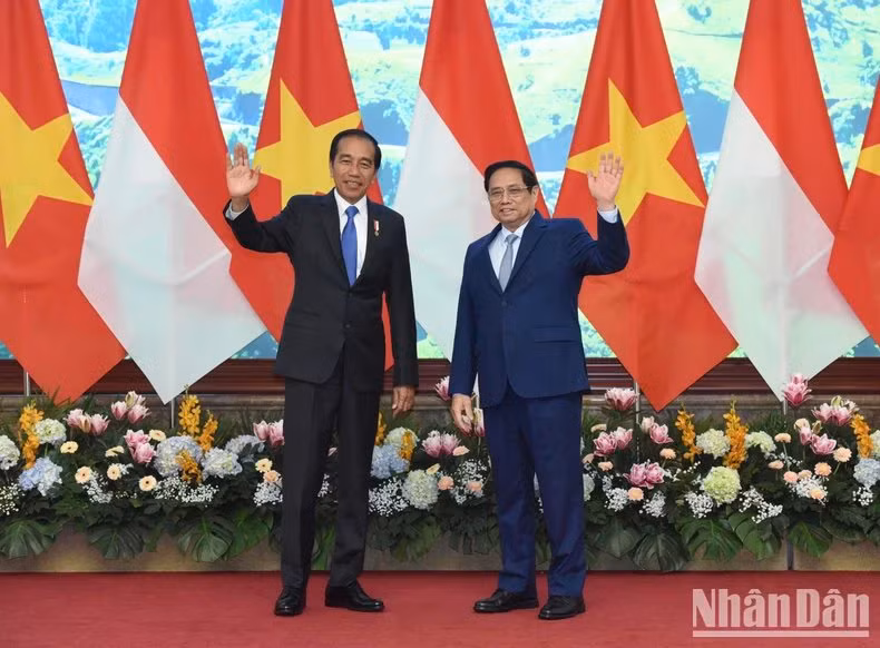 El primer ministro Pham Minh Chinh y el presidente de Indonesia, Joko Widodo, saludan a los periodistas.