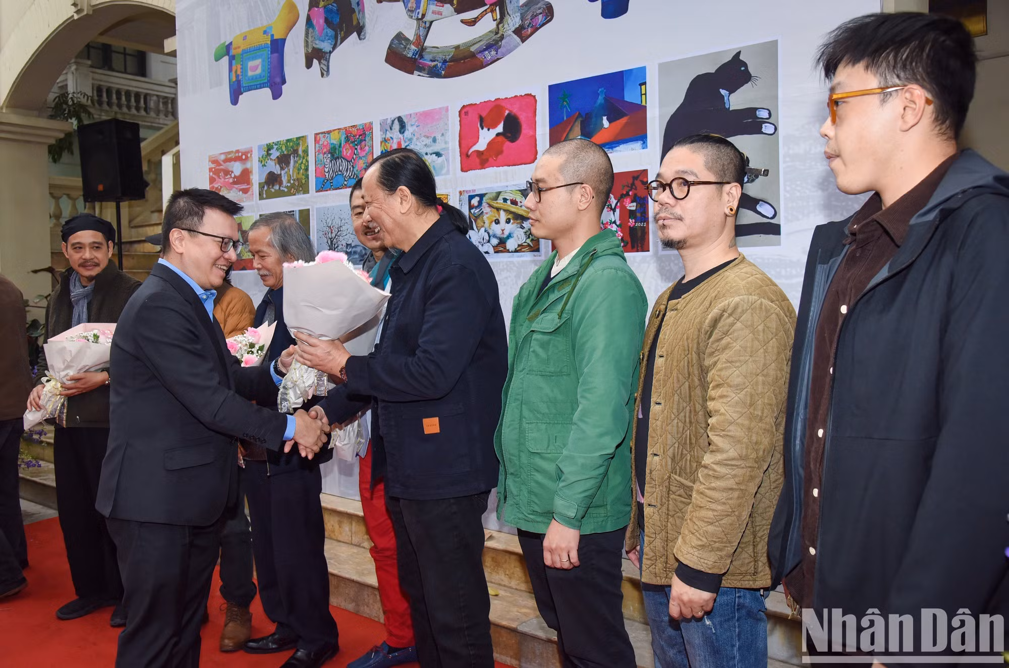 El presidente-editor de Nhan Dan, Le Quoc Minh, entrega flores a los artistas participantes en el proyecto. (Foto: Tran Hai)