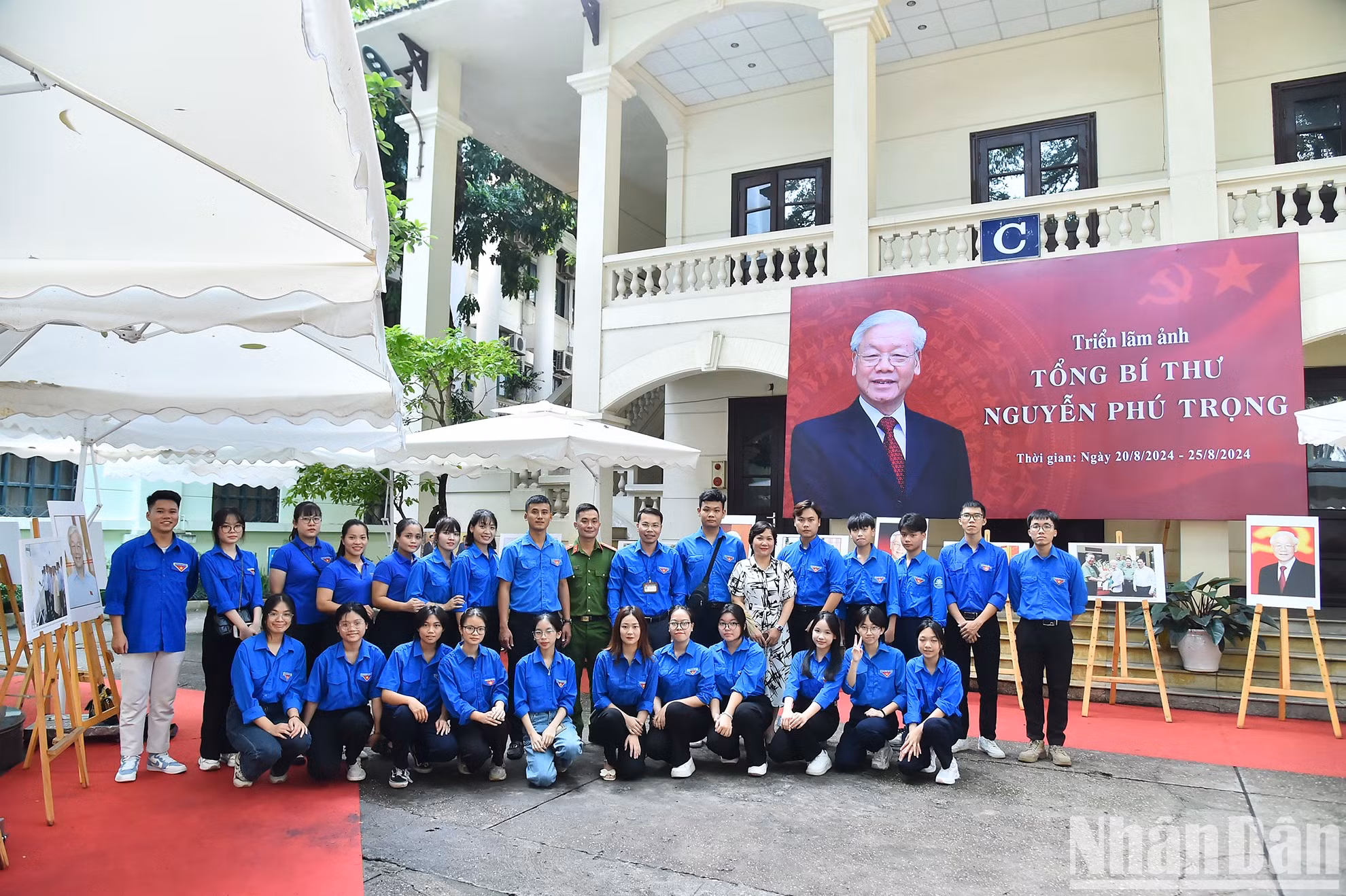 Representantes del periódico Nhan Dan y jóvenes de la comuna de Dong Hoi en la exposición fotográfica.