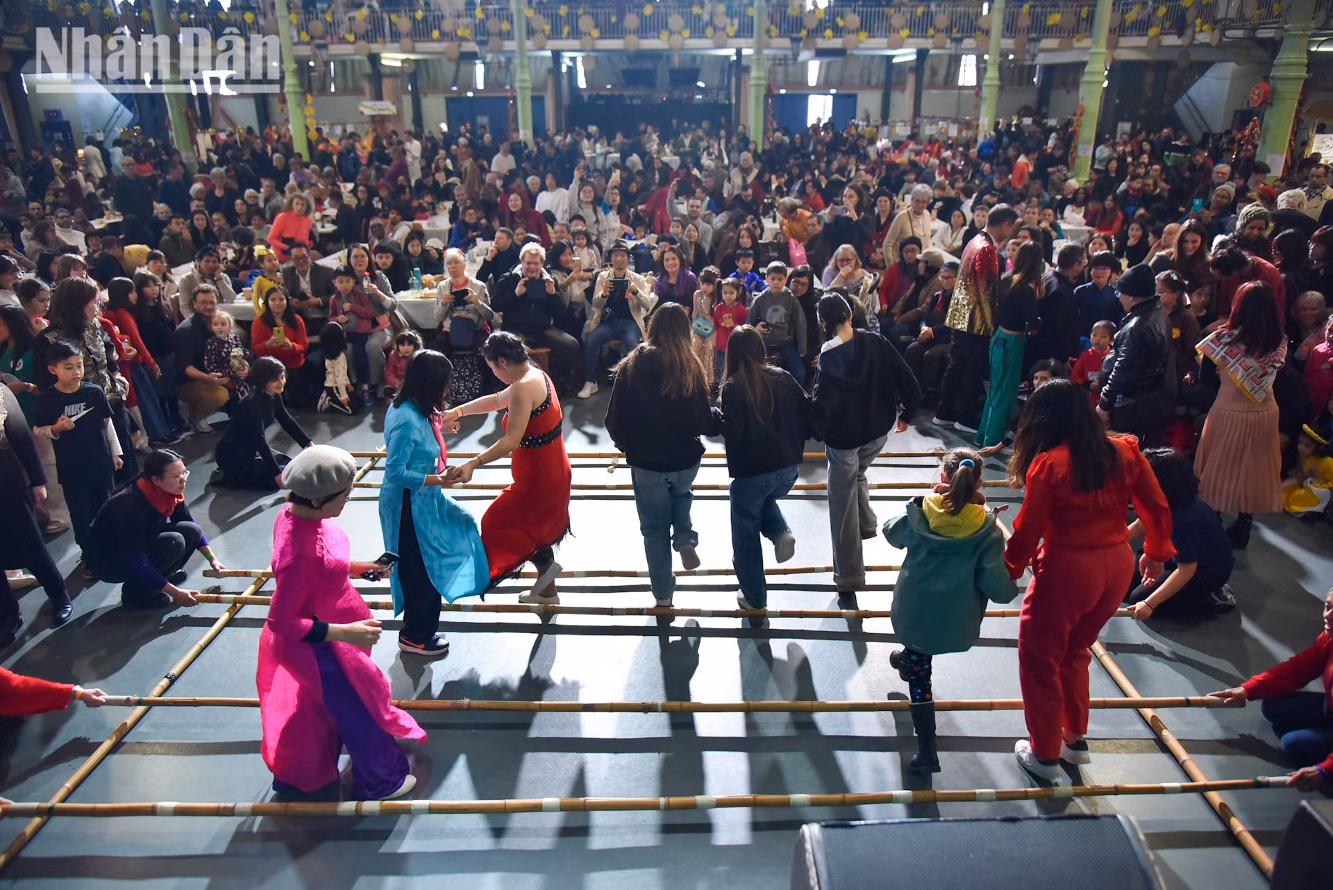 Los vietnamitas residentes en Francia y amigos internacionales participan en la danza del bambú, un baile tradicional de la etnia Thai de la región montañosa del norte de Vietnam.
