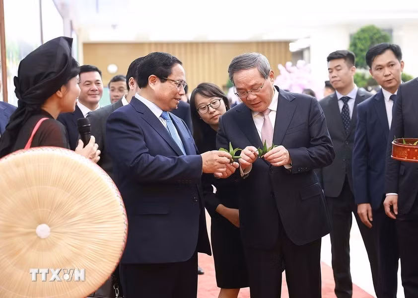 Los dos premieres disfrutan del Trau tiem canh phuong (quid de betel en forma de alas de fénix) de la cultura de Kinh Bac.