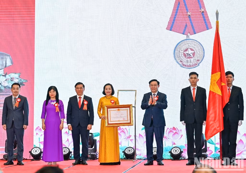 El presidente de la AN, Vuong Dinh Hue, entrega la distinción al comité.