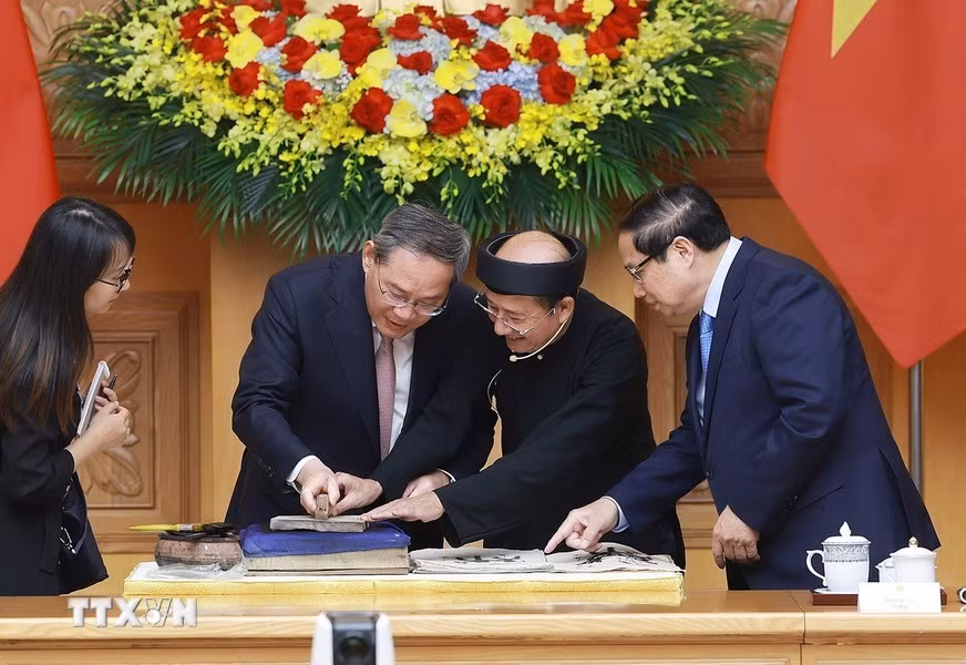 El primer ministro vietnamita, Pham Minh Chinh, y su similar chino, Li Qiang, experimentan la elaboración de una pintura folclórica de Dong Ho.