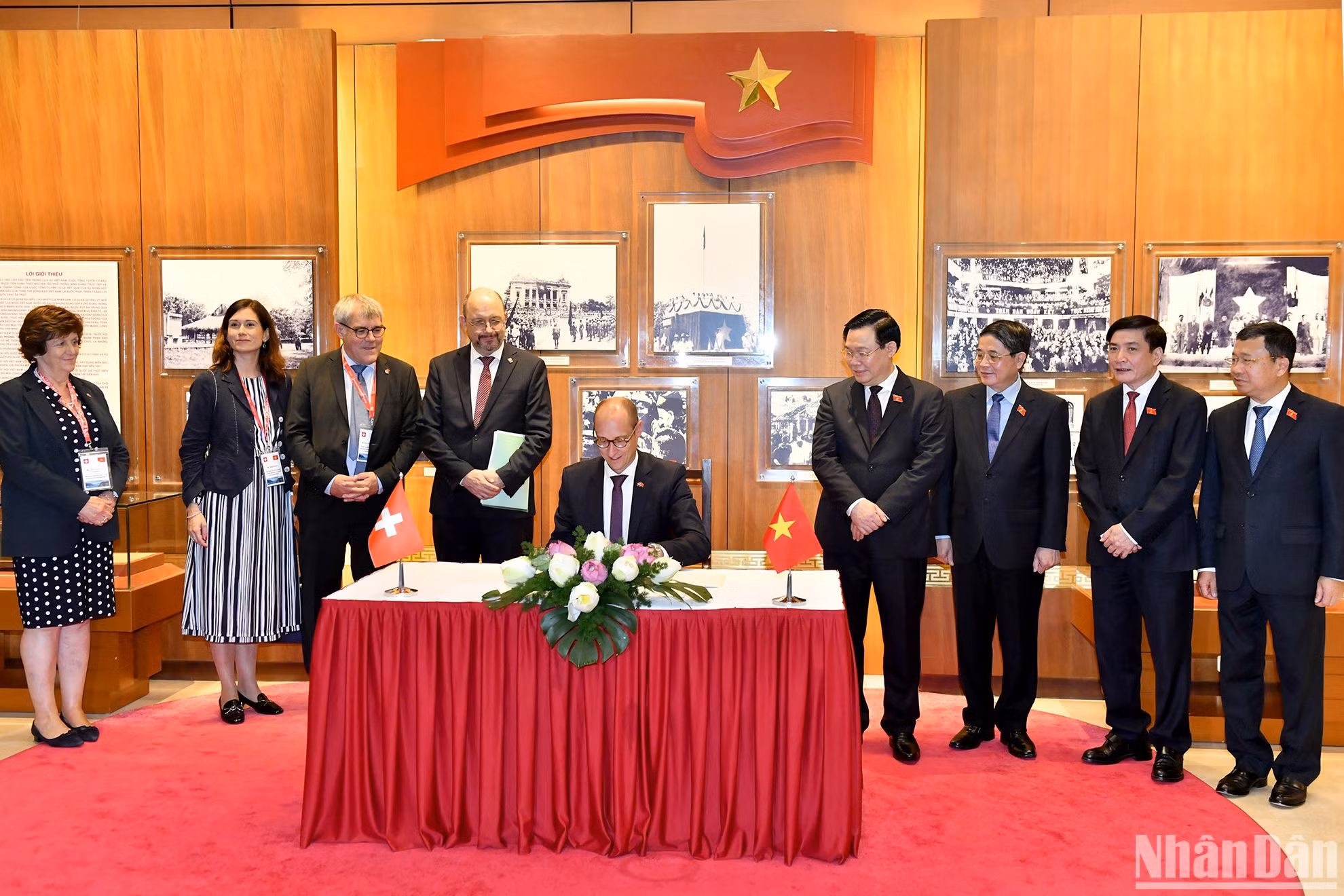 El dirigente legislativo suizo firma el libro de oro de recuerdo en la Casa tradicional de la AN de Vietnam.