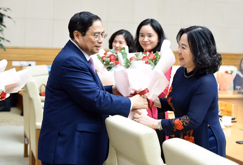 El primer ministro entrega flores a las delegadas.