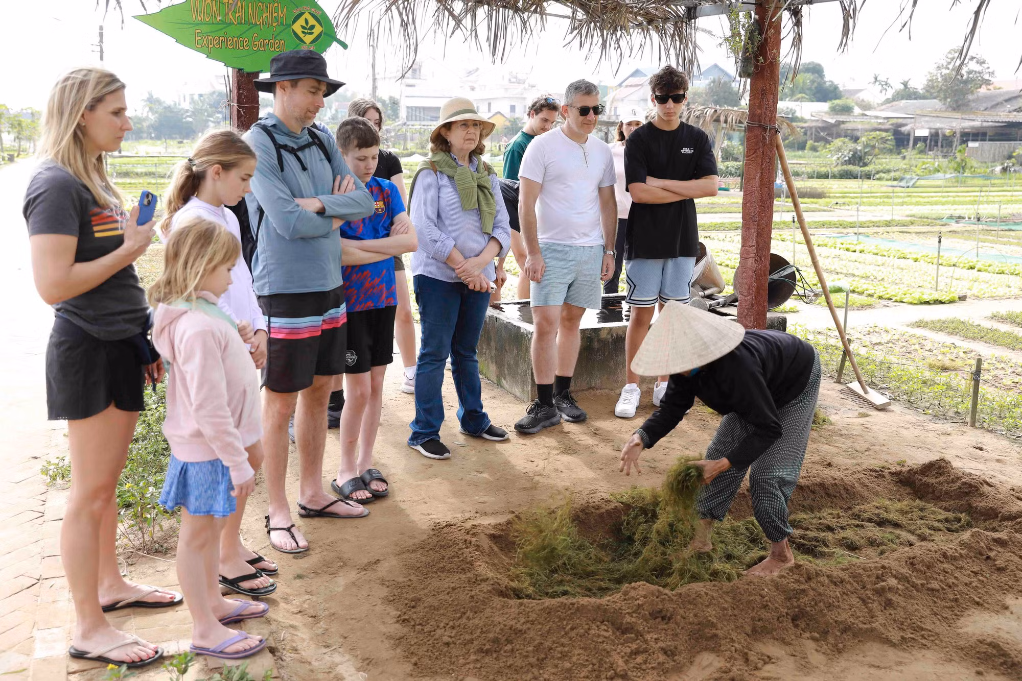 Turistas extranjeros aprenden las prácticas locales de cultivo.