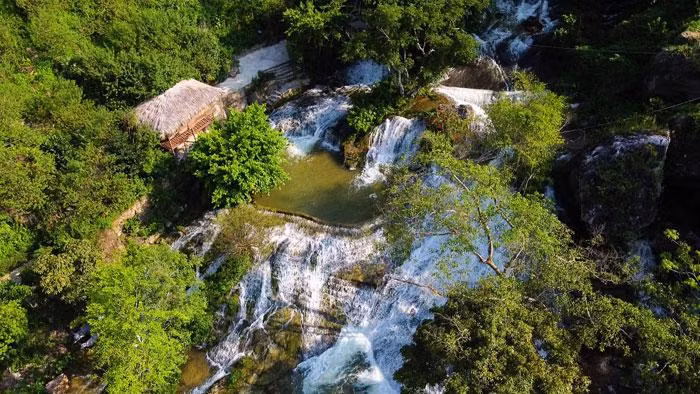 La cascada fluye a través de las laderas rocosas en medio de las montañas y los bosques. La cascada fluye a través de las laderas rocosas en medio de las montañas y los bosques.