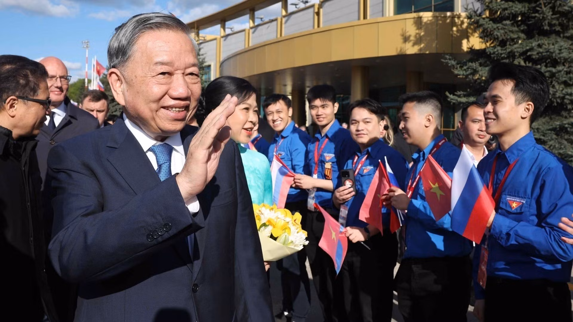 Representantes de la comunidad vietnamita en Rusia dan la bienvenida al líder partidista y a su esposa en el aeropuerto Vnúkovo 2, en Moscú.