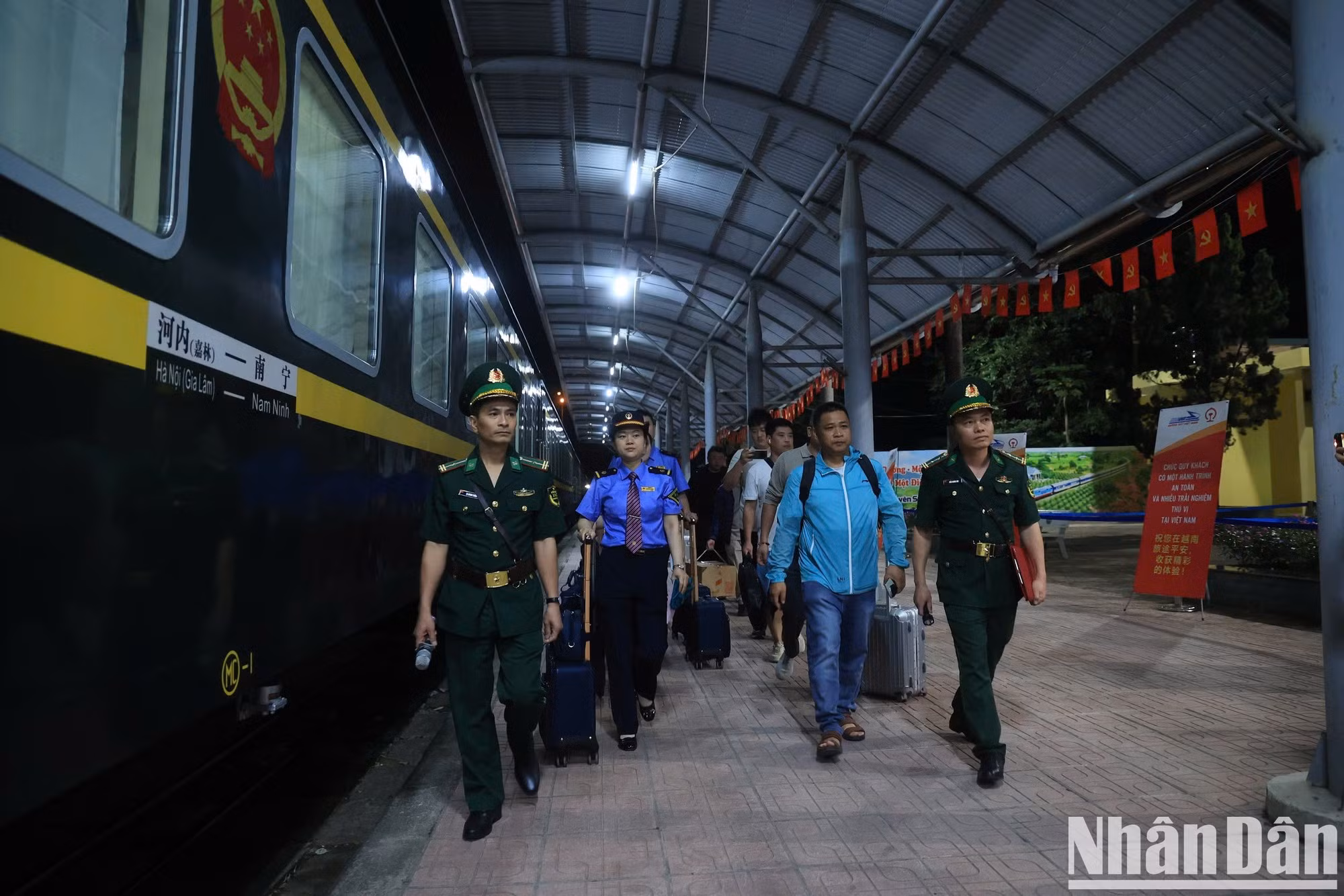 La tripulación del tren y los pasajeros se bajan al andén en Dong Dang para realizar los procedimientos de ingreso.