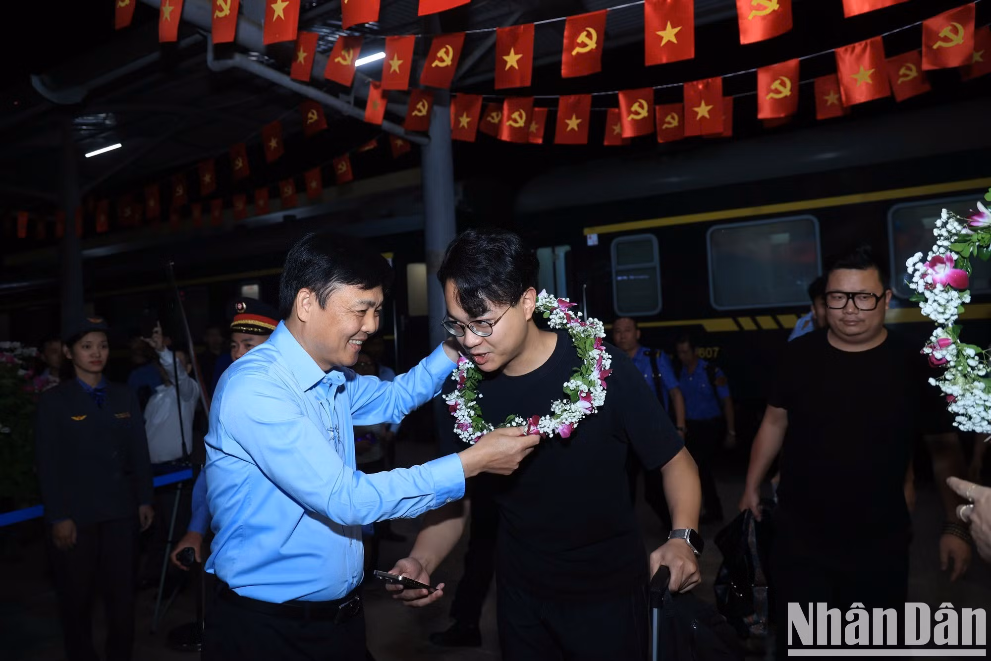 El director general de la Corporación de Ferrocarriles de Vietnam, Hoang Gia Khanh, entrega flores para dar la bienvenida a los primeros pasajeros del tren transfronterizo de pasajeros, recientemente reanudado en la estación de Dong Dang.