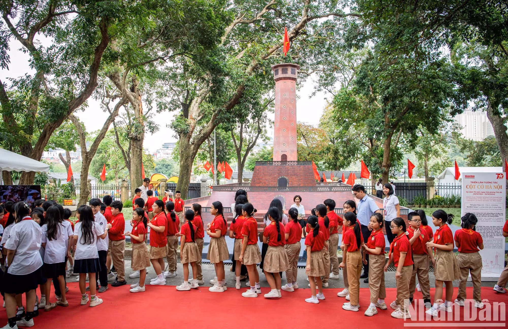 Los alumnos visitan el maqueta de la Torre de la Bandera de Hanói, colocada en la sede del periódico Nhan Dan.