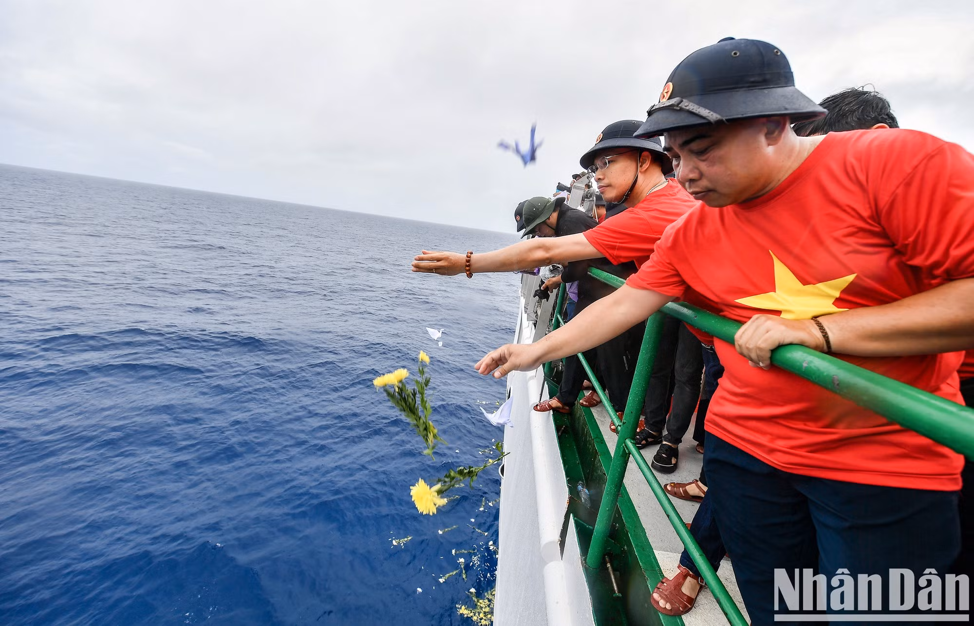 El periodista Pham Huu Quang, subdirector de la revista Ngay Nay (Hoy), no puede contener las lágrimas mientras deja caer flores y grullas de papel para honrar a los mártires.