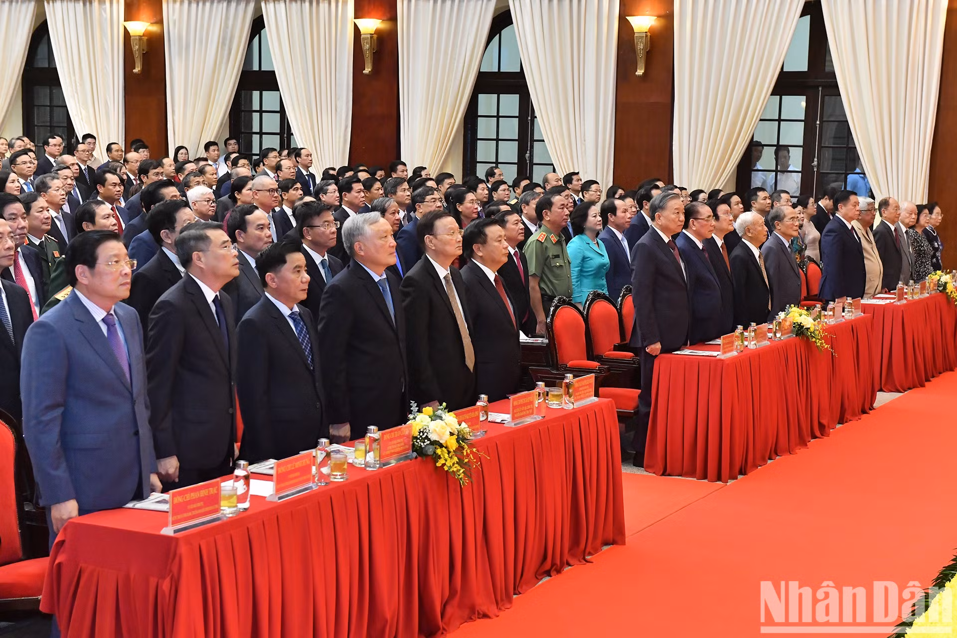 Los delegados saludan a la bandera nacional.