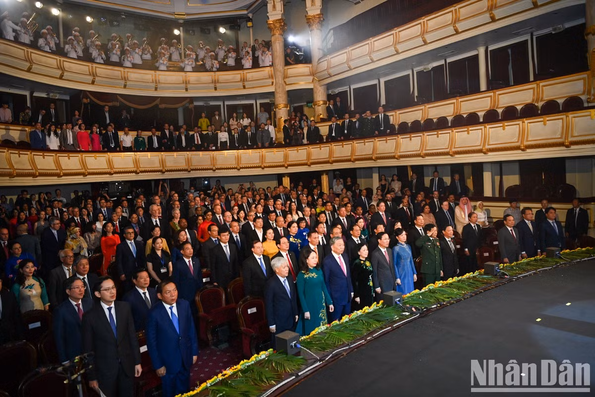Los asistentes saludan a la bandera nacional.