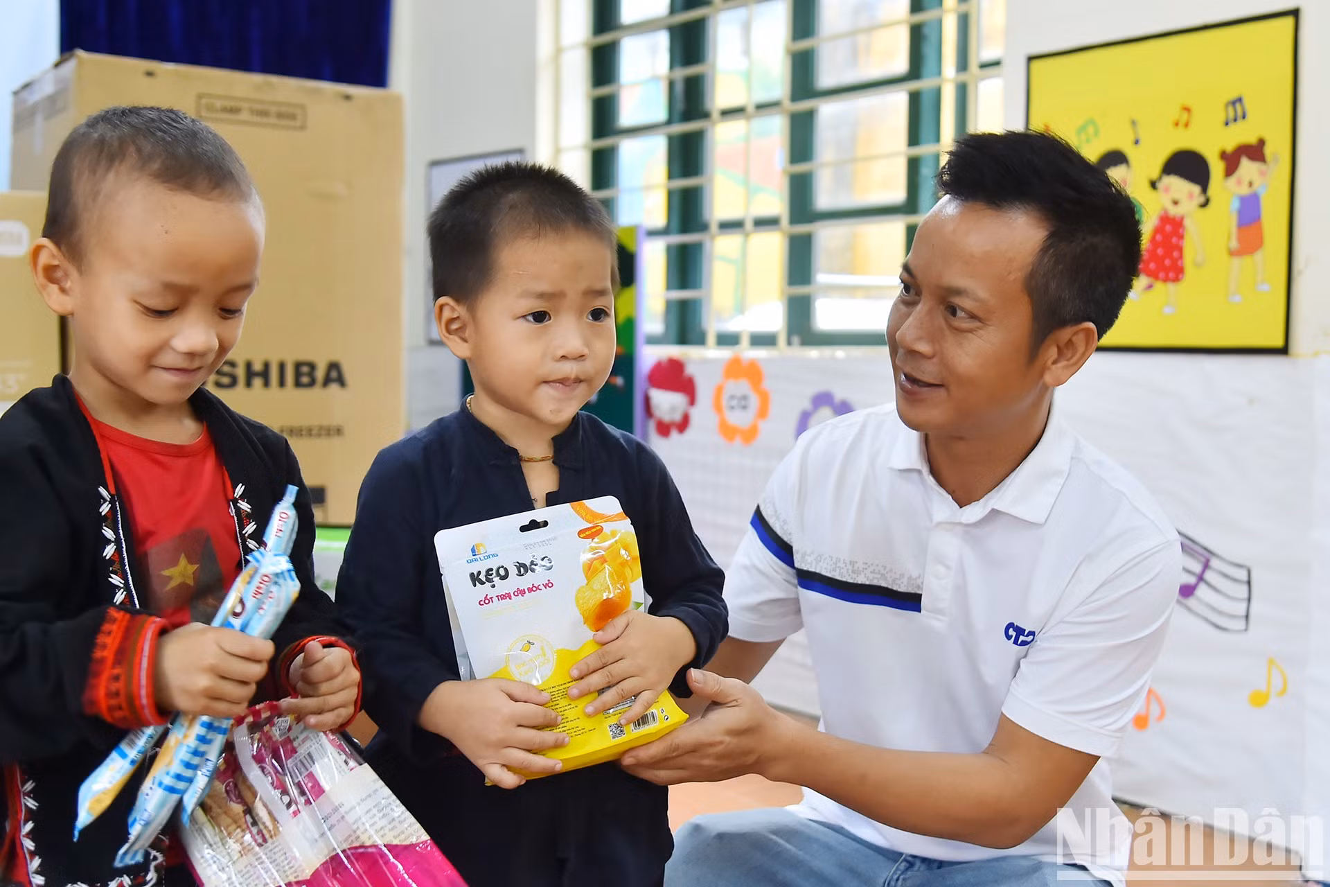 El representante de la Compañía de Inversión y Construcción CTA Vietnam entrega obsequios a los niños.