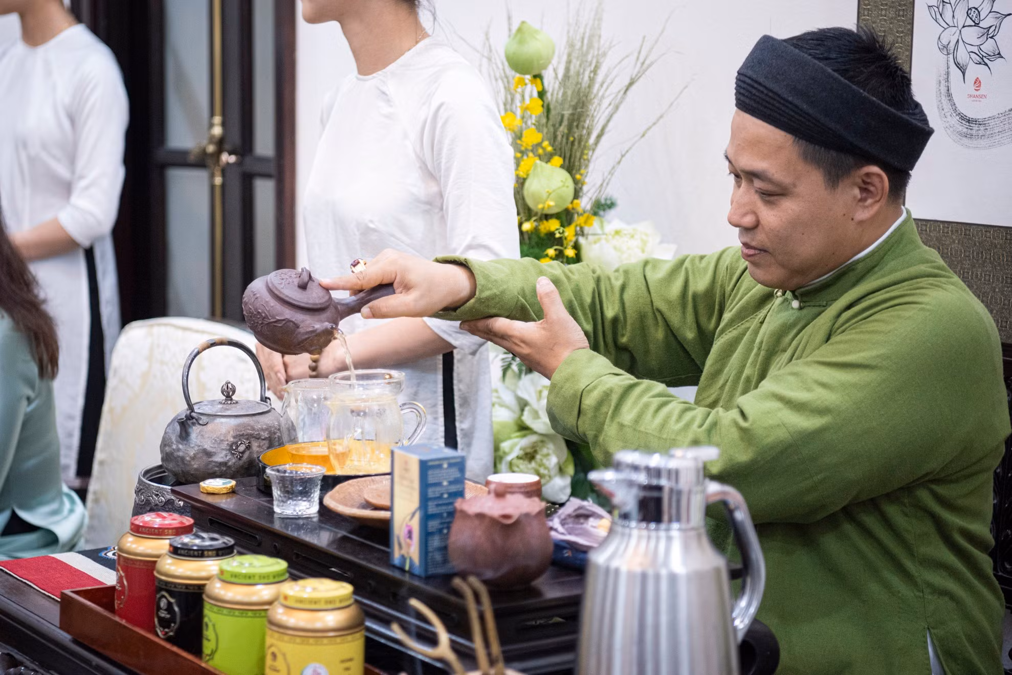 El artesano Dao Duc Hieu prepara té para las dos damas.