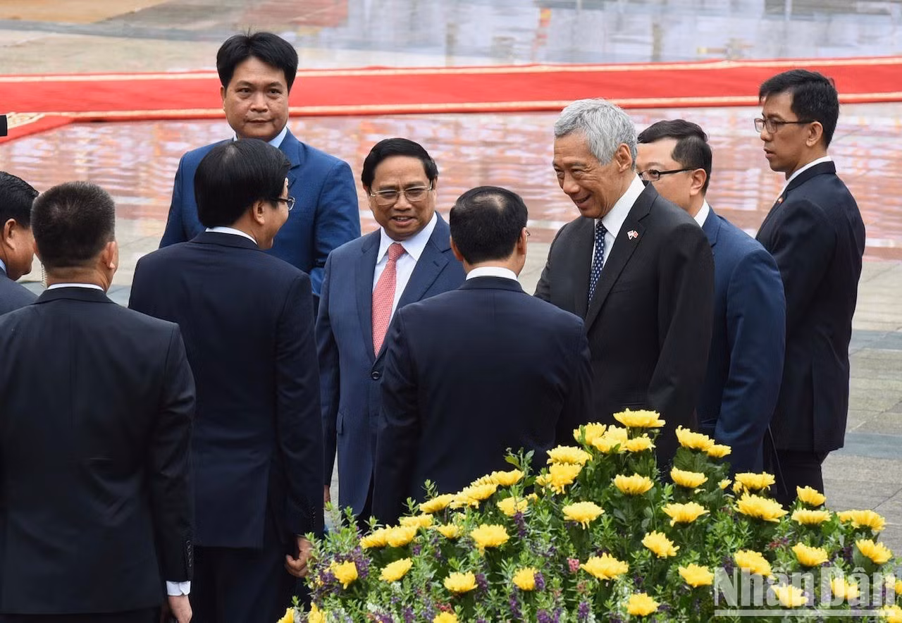 Minh Chinh presenta a su par singapurense los delegados vietnamitas.