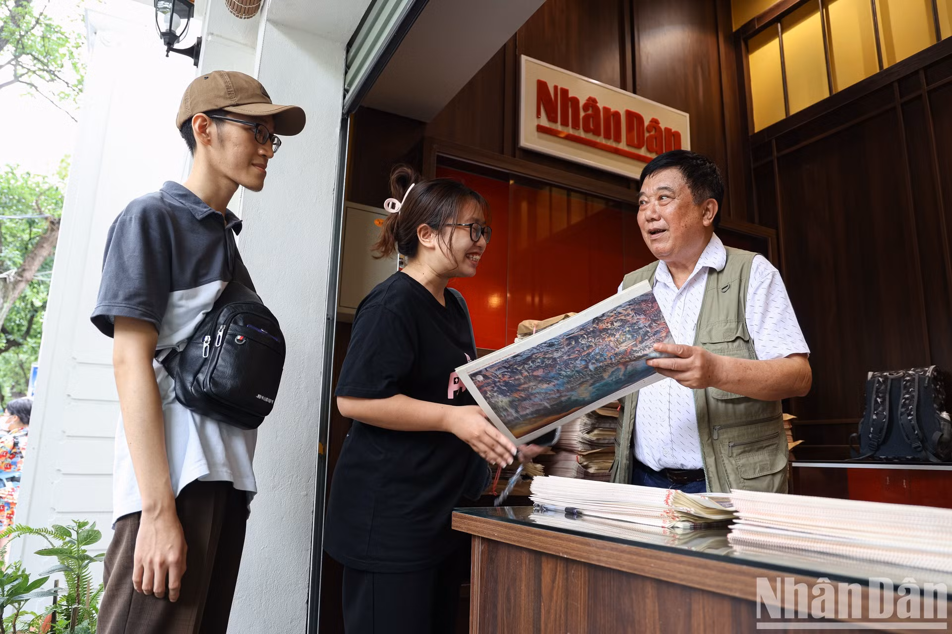 El pintor Nguyen Van Mac, autor de la pintura panorámica, firma autógrafos a los lectores.