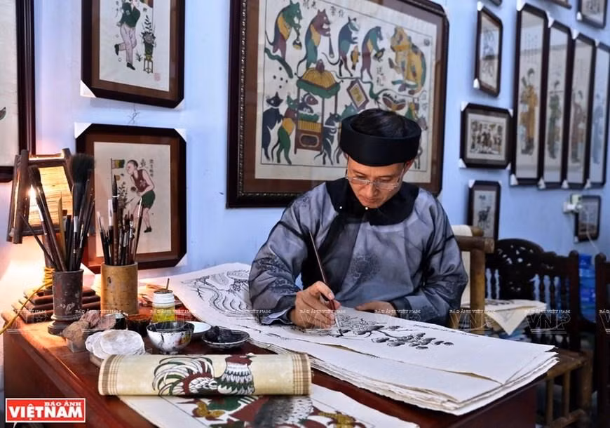 Después de estampar las características básicas, los artesanos de la aldea de pintura Dong Ho continúan dibujando a mano para completar el cuadro.