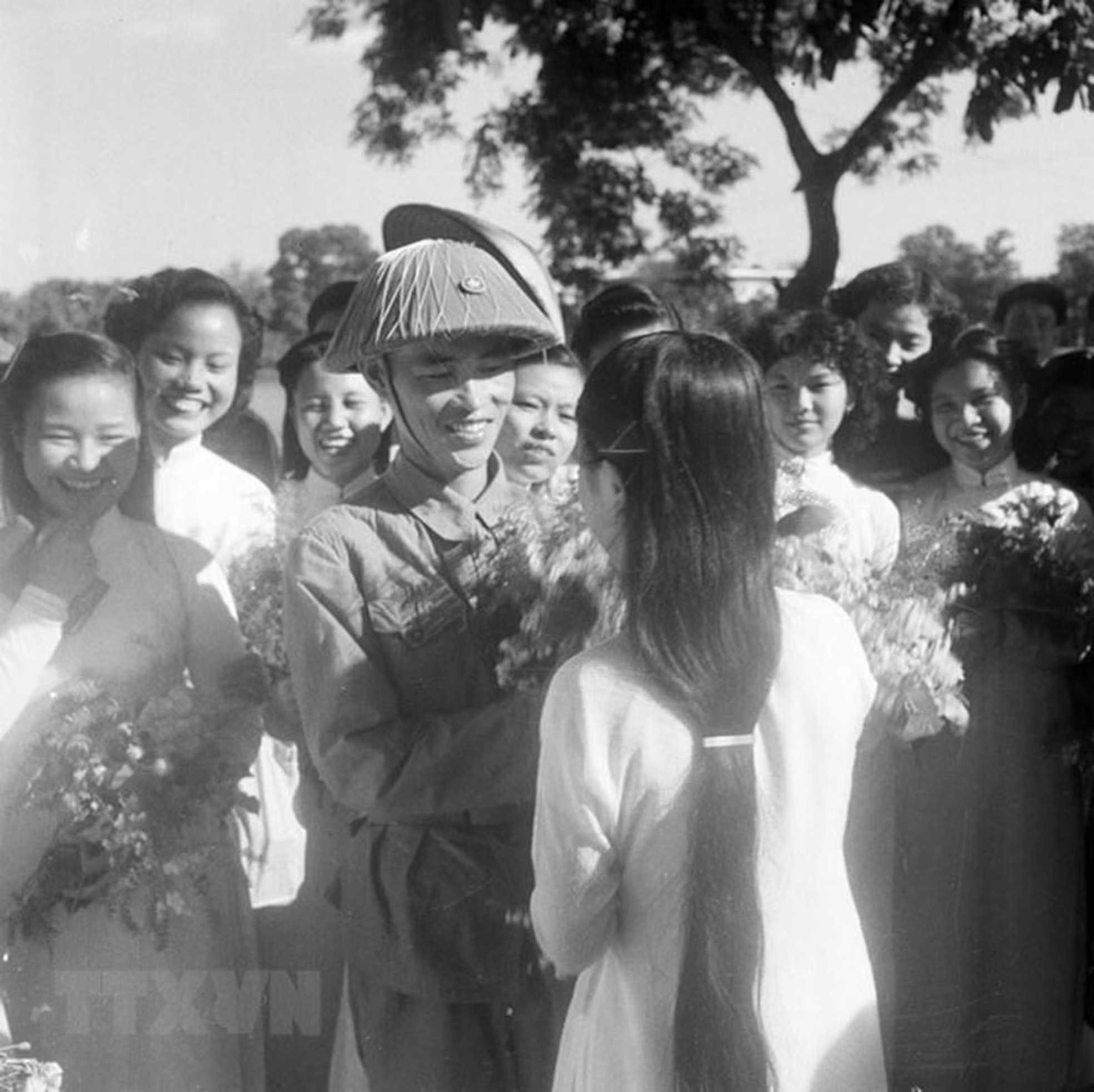 El mayor general Vuong Thua Vu, comandante de la División 308 y presidente de la Comisión Militar de Hanói, recibe flores de felicitación de las alumnas de la Escuela Trung Vuong, al lado del lago Hoan Kiem en el Día de la Liberación de la Capital.