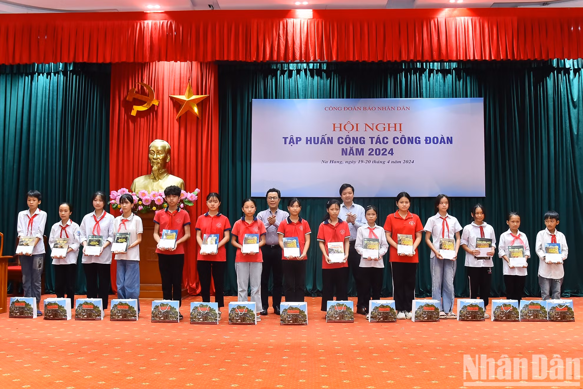 El jefe de Comunicación y Educación del Comité del Partido Comunista de Vietnam en el periódico Nhan Dan, Vu Mai Hoang, y el vicepresidente del Sindicato de Nhan Dan Ta Quang Dung, otorgan regalos a los menores de edad.