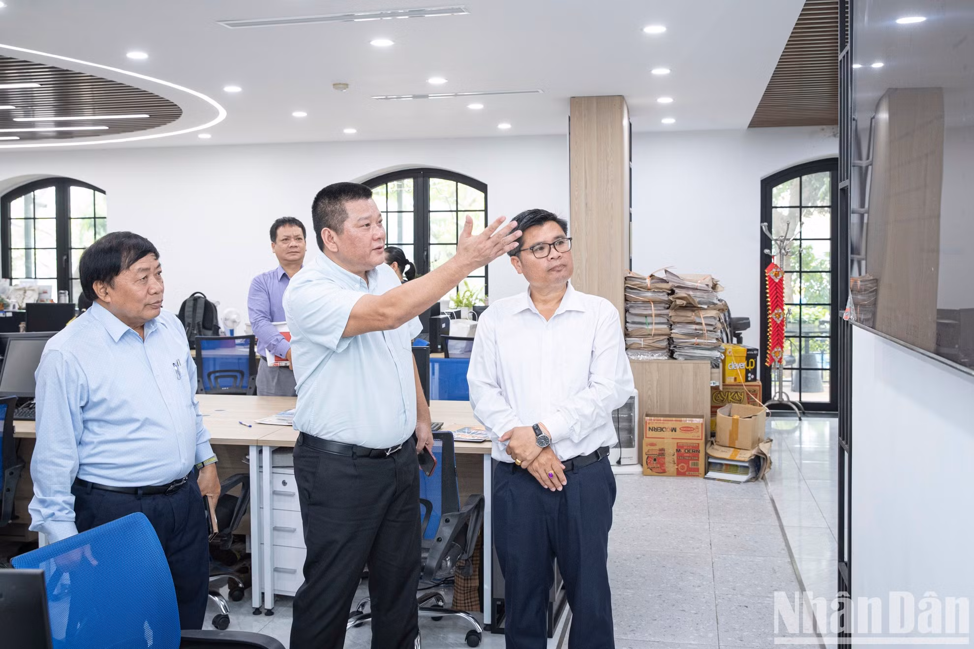 El jefe de la Redacción de Nhan Dan Digital, Nguyen Ngoc Thanh, presenta a los visitantes el nuevo despacho de trabajo del departamento.