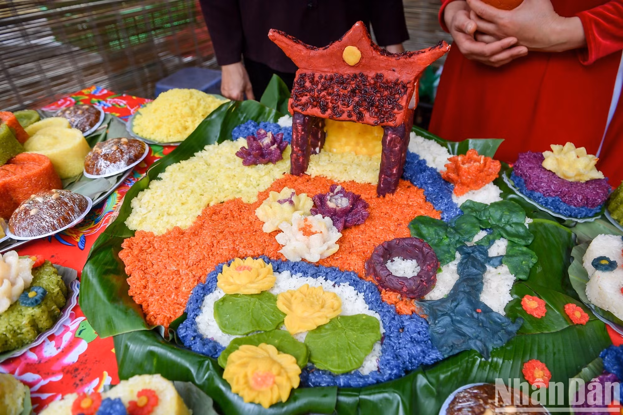 Una bandeja de “xôi” inspirada en paisajes de la milenaria aldea a orillas del Río Rojo. Según ancianos locales, hay tres artesanos y unas 600 familias en Phu Thuong actualmente dedicados a la cocción de arroz glutinoso, y hasta cien aldeanos a la venta del manjar. Este plato ha ayudado a la gente allí a llenar la barriga en tiempos de hambruna y también se ha convertido en un producto de alta rentabilidad.
