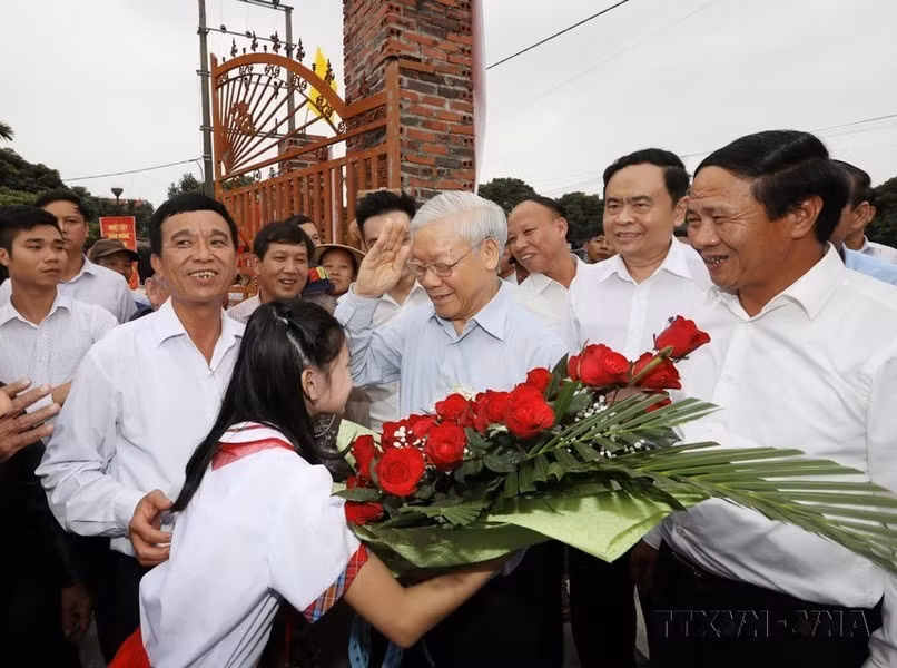 Niños de la aldea de Thuong Dien, comuna de Vinh Quang, entregan flores de bienvenida al secretario general del Partido, Nguyen Phu Trong, en ocasión de su asistencia a la Fiesta de Gran Unidad Nacional en la ciudad de Hai Phong, el 15 de noviembre de 2017.