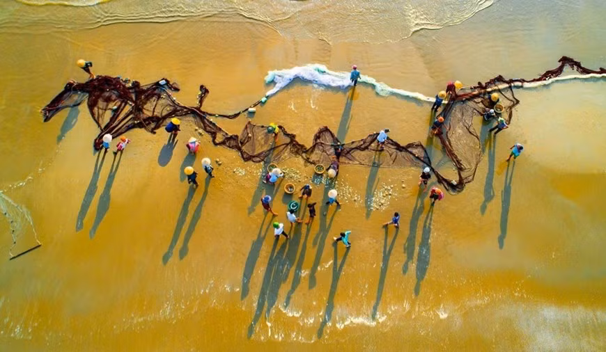 Pescadores en la playa de Loc Ha.