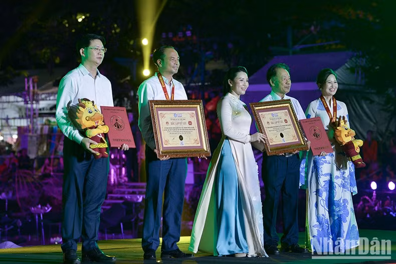 En la ceremonia inaugural, el Comité Organizador entrega los premios del concurso “La bella en ‘ao dai’ (túnica tradicional de los vietnamitas) y el loto”, y certificados de reconocimiento a dos récords, “El mayor número de personas vestidas de ‘ao dai’ con patrones de loto en Vietnam” (mil personas) y “El recorrido por el Lago Oeste en bicicleta con el mayor número de participantes en Vietnam” (siete mil).
