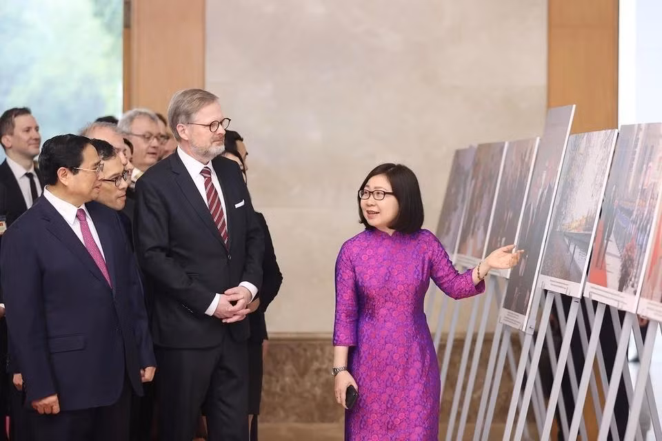 La directora general adjunta de la Agencia Vietnamita de Noticias, Doan Thi Tuyet Nhung, presenta una exposición fotográfica sobre las relaciones amistosas entre Vietnam y la República Checa a los dos primeros ministros (Hanói, 21 de abril de 2023).