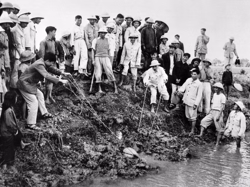 El Presidente Ho Chi Minh achica agua para combatir la sequía con los agricultores de la comuna de Dai Thanh, provincia de Ha Dong (actualmente Hanói), el 12 de enero de 1958.