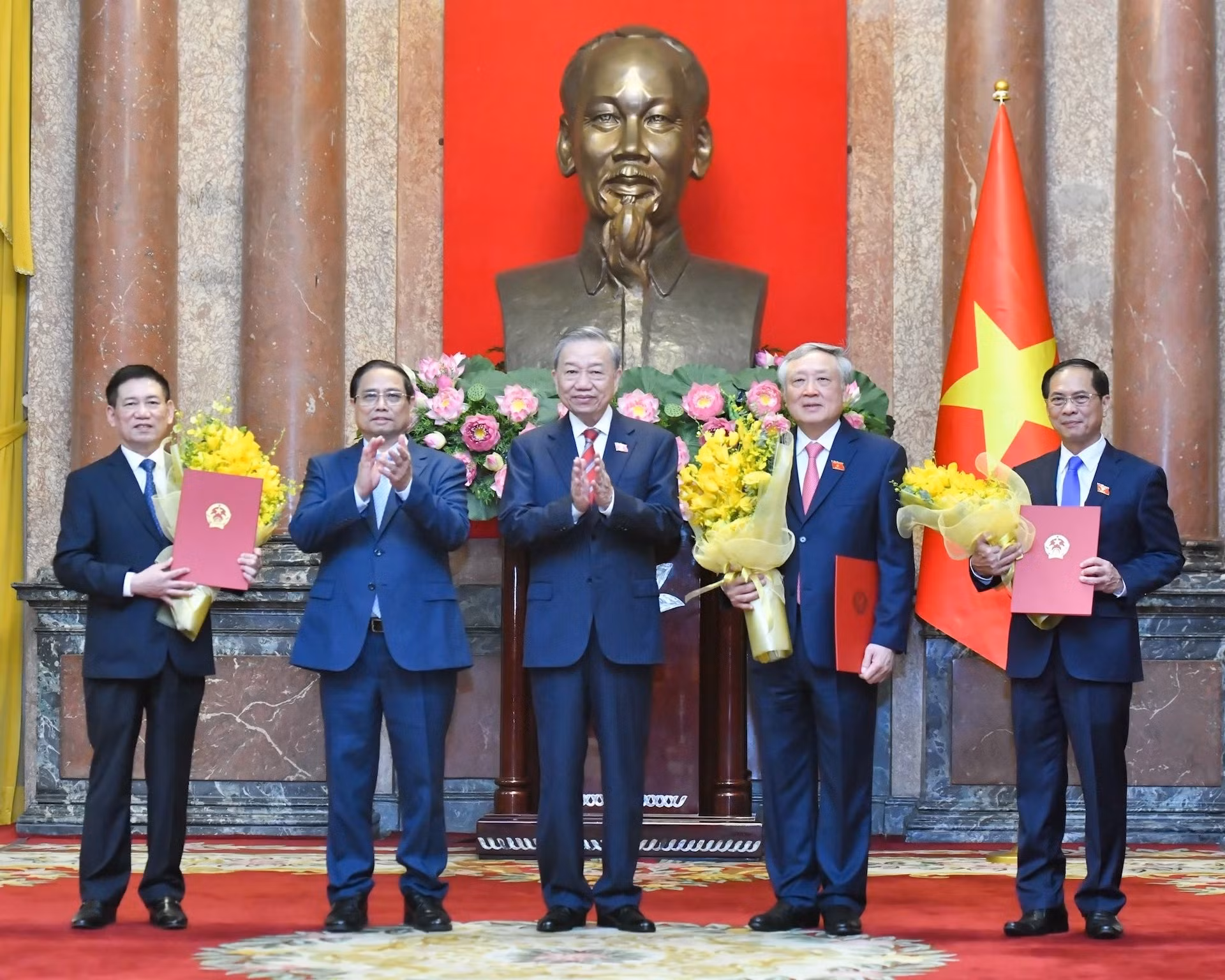 El secretario general del PCV y presidente To Lam entrega las decisiones y el premier Pham Minh Chinh flores de felicitación a los nuevos subjefes de Gobierno.