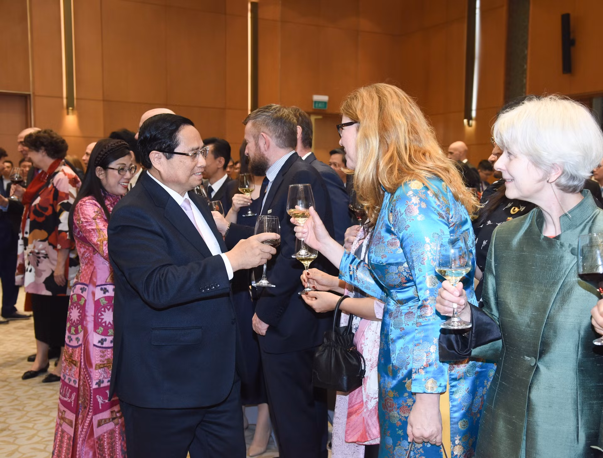 El dirigente vietnamita y su esposa saludan a los diplomáticos.