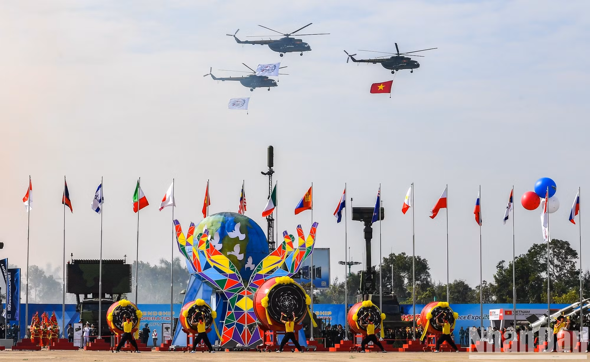 Helicópteros vuelan con la bandera nacional de Vietnam y la bandera de la exposición.