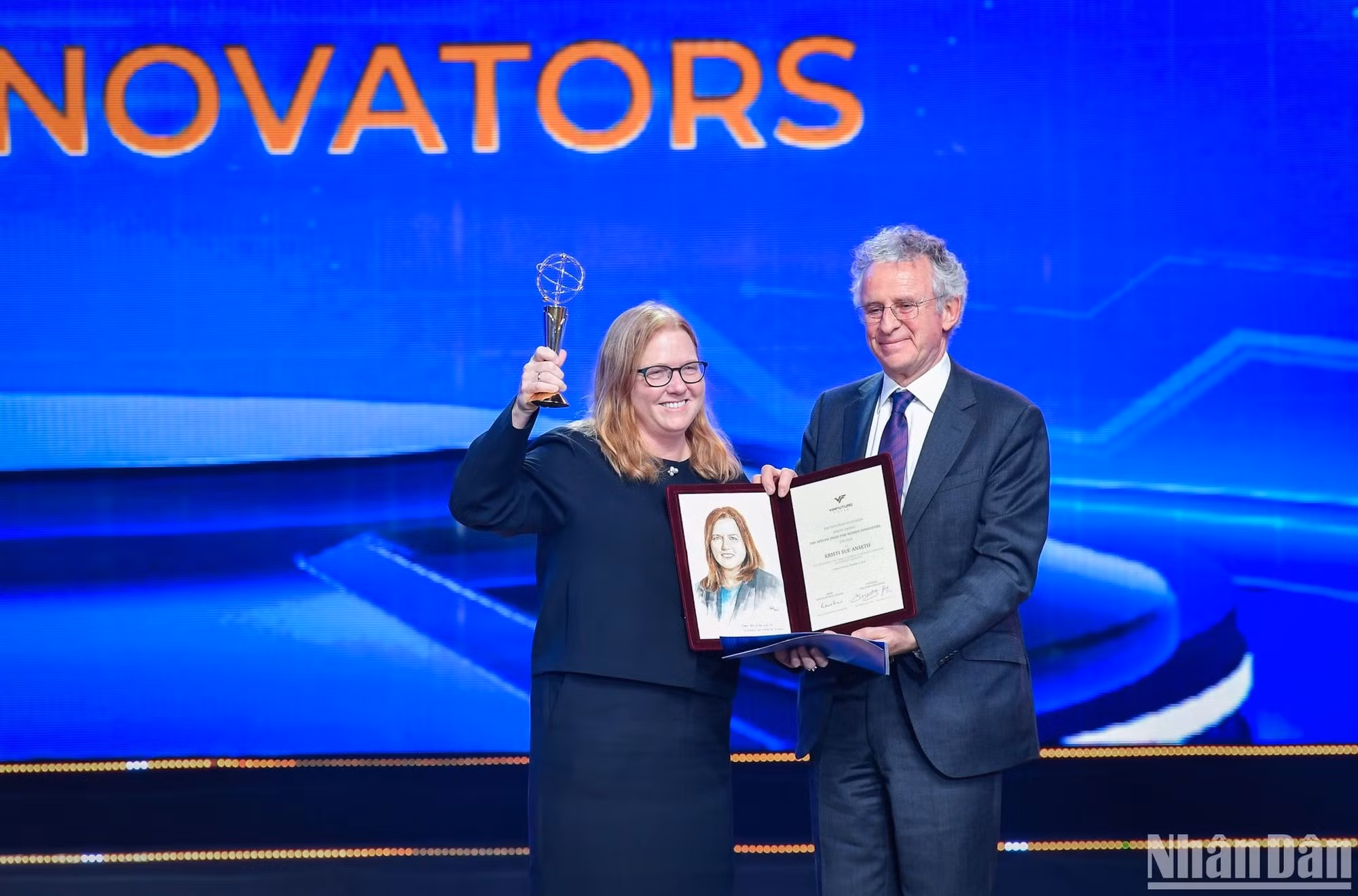El profesor Richard Henry Friend, presidente del Consejo de los Premios de VinFuture, entrega el trofeo y el certificado a la profesora Kristi S. Anseth, ganadora del Premio Especial para Mujeres Científicas por lograr avances en el diseño de materiales poliméricos y métodos para aplicaciones biomédicas.