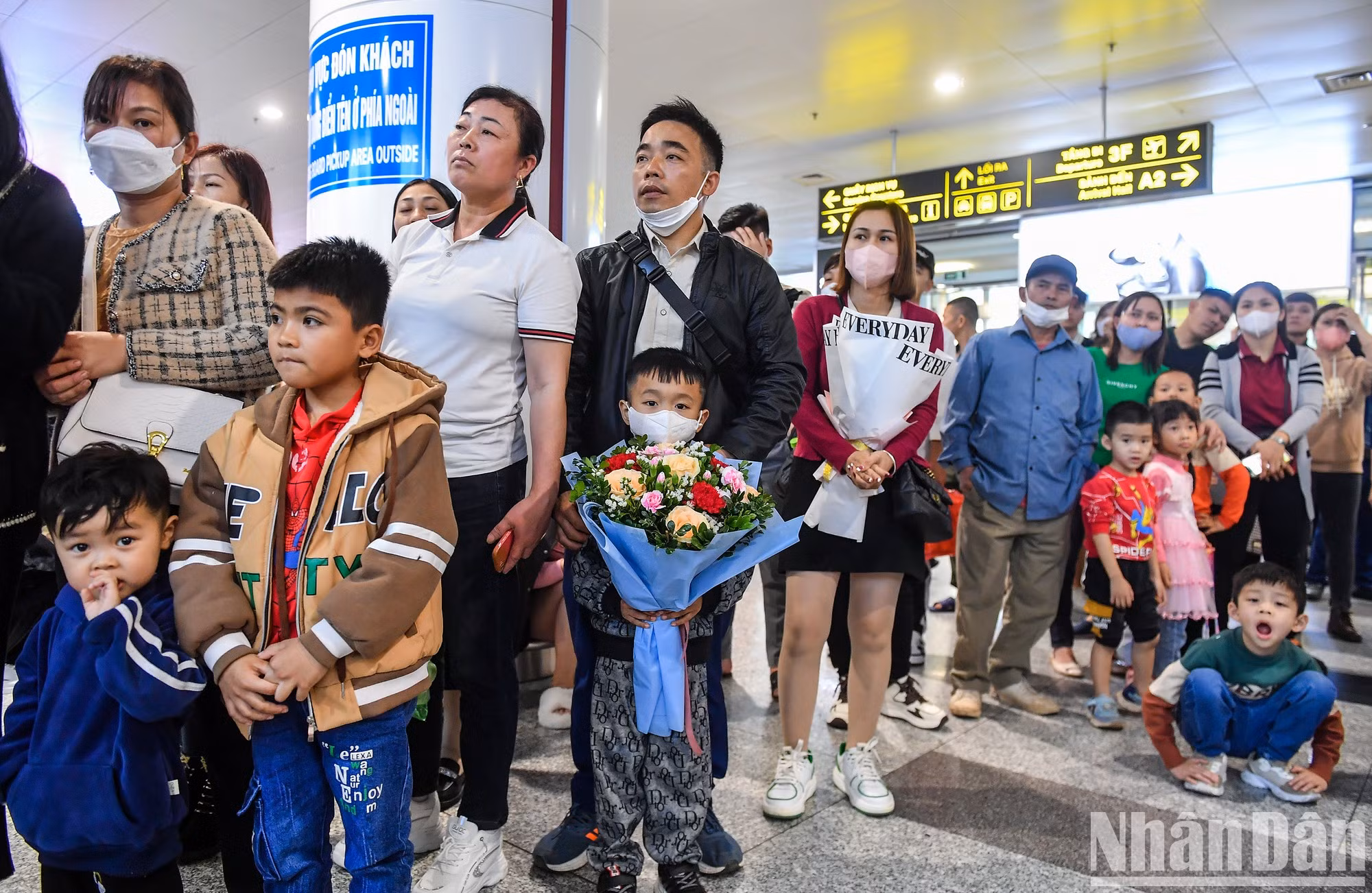 En la Terminal de pasajeros T2, muchas personas esperan el aterrizaje de vuelos internacionales.