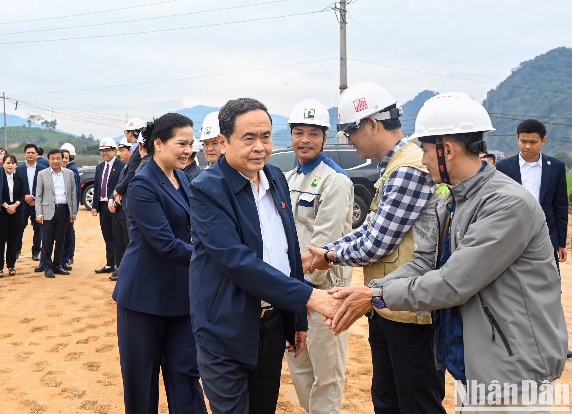 El titular de la Asamblea Nacional vietnamita, Tran Thanh Man, e ingenieros y trabajadores en el sitio de construcción.
