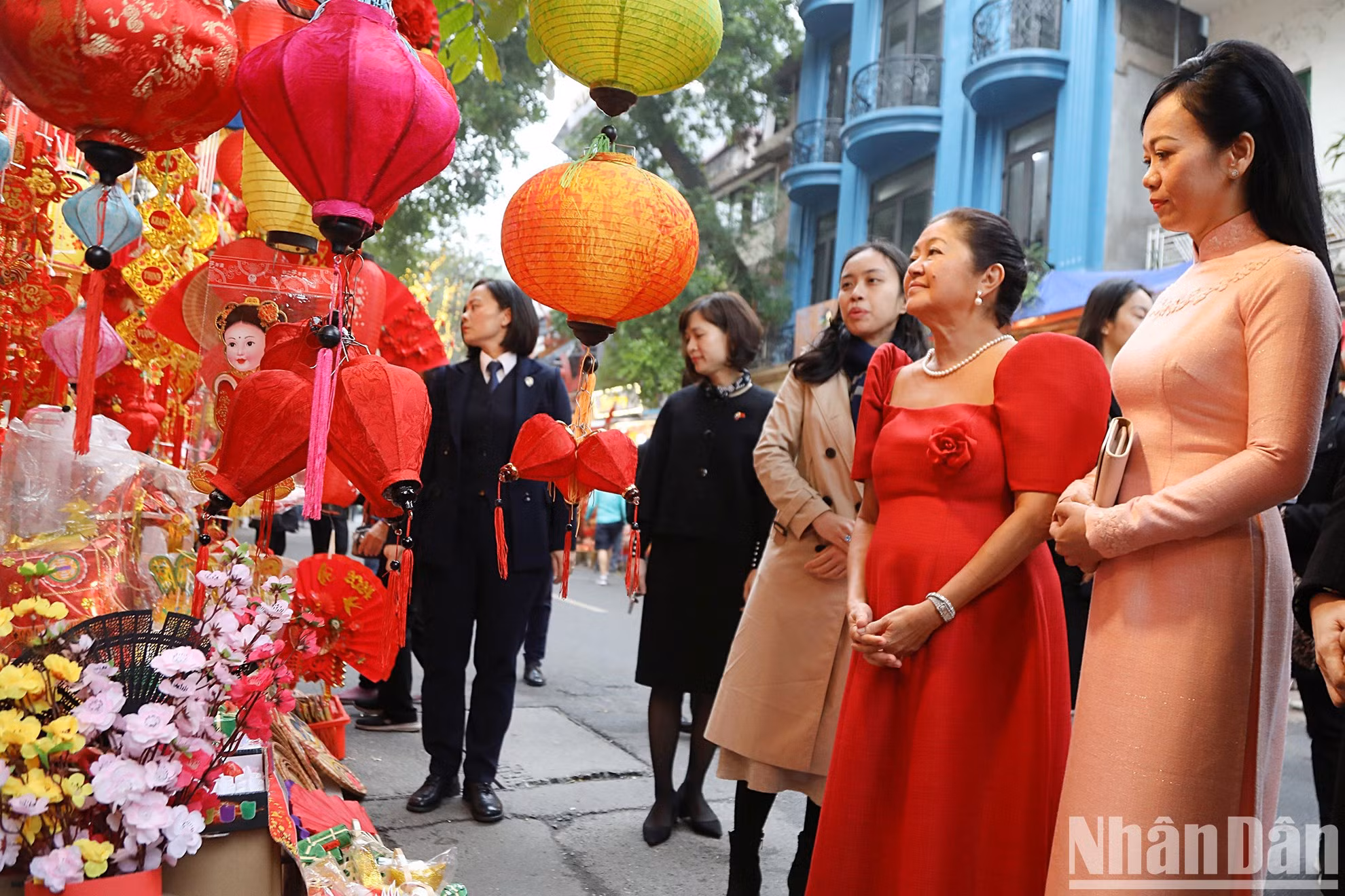 Thanh Tam y Louise Araneta escuchan una introducción a las decoraciones que se venden en la calle de Hang Ma.