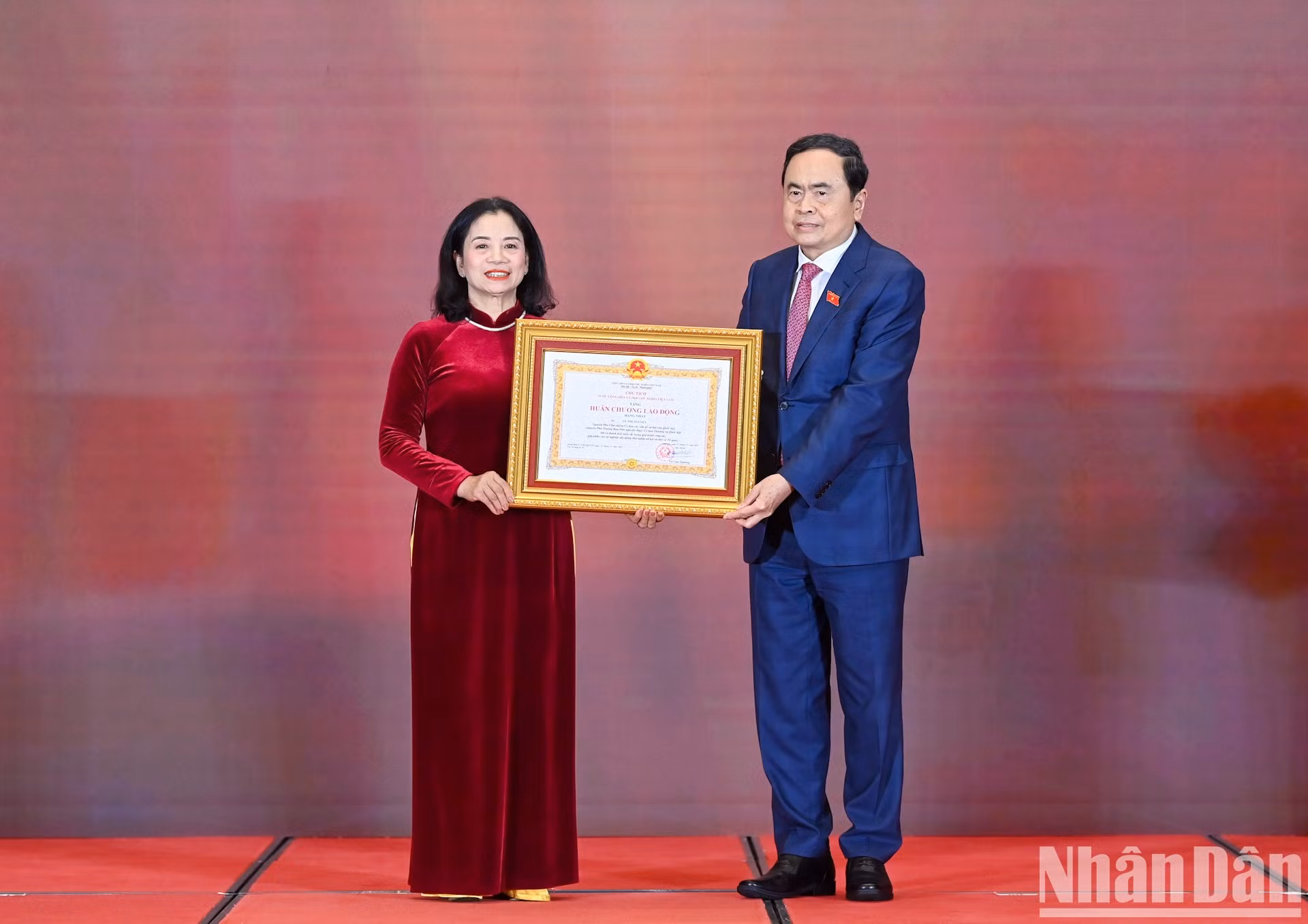 El presidente de la Asamblea Nacional vietnamita, Tran Thanh Man, entrega la Medalla Laboral de Primera Clase a la camarada Le Thi Nguyet.